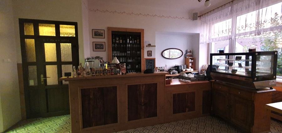 Bar s kávovarem a vitrínou se zákusky